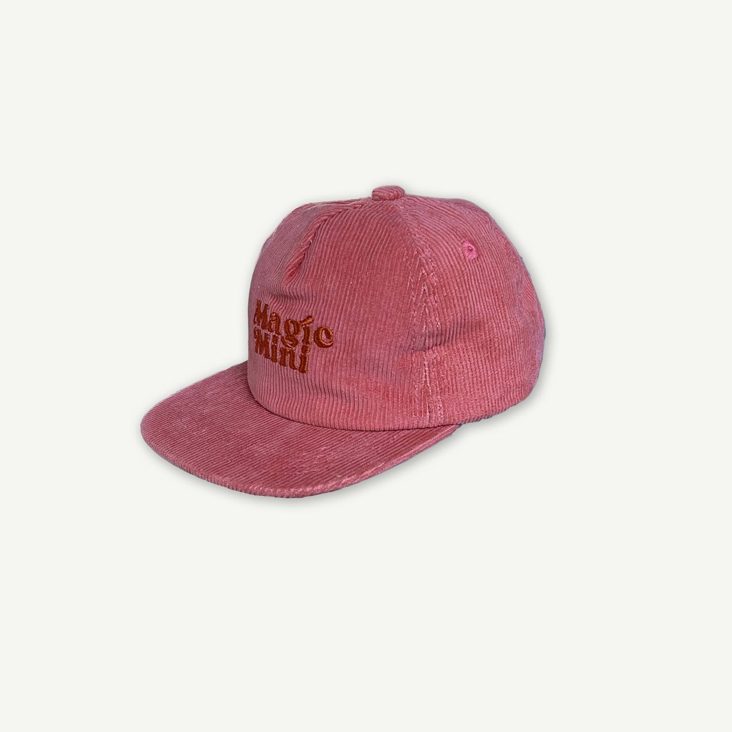 Side view of Magic Mini Cord Cap.  Cap is Pink with Magic Mini embroidered on the center front 