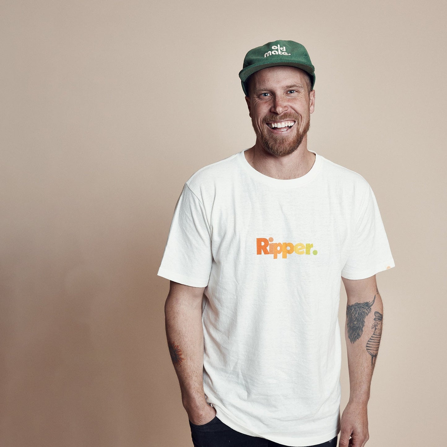 Man wearing Moss green corduroy pinch front cap with old mate embroidered on center front in contrast off white and White T-shirt with Ripper written across the front. 