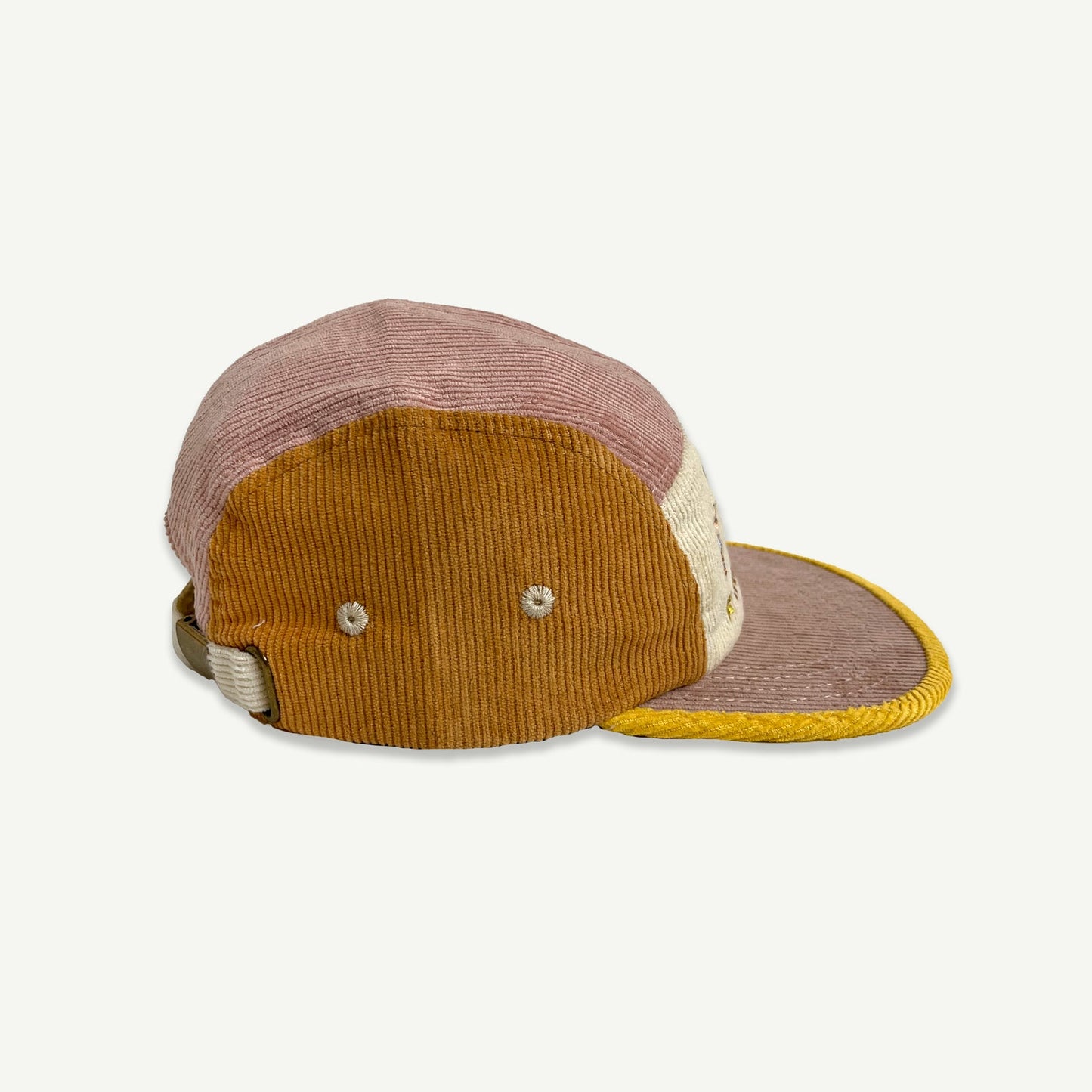 Side view of 1st Birthday Cord Cap Musk Splice. which is a 5 panel  cap , colour blocked in musk pink, orange and yellow.  Cap peak is musk pink with yellow bind. Front section is natural with embroidery in multicolored thread saying HIP HIP HOORAY, 1 IS 