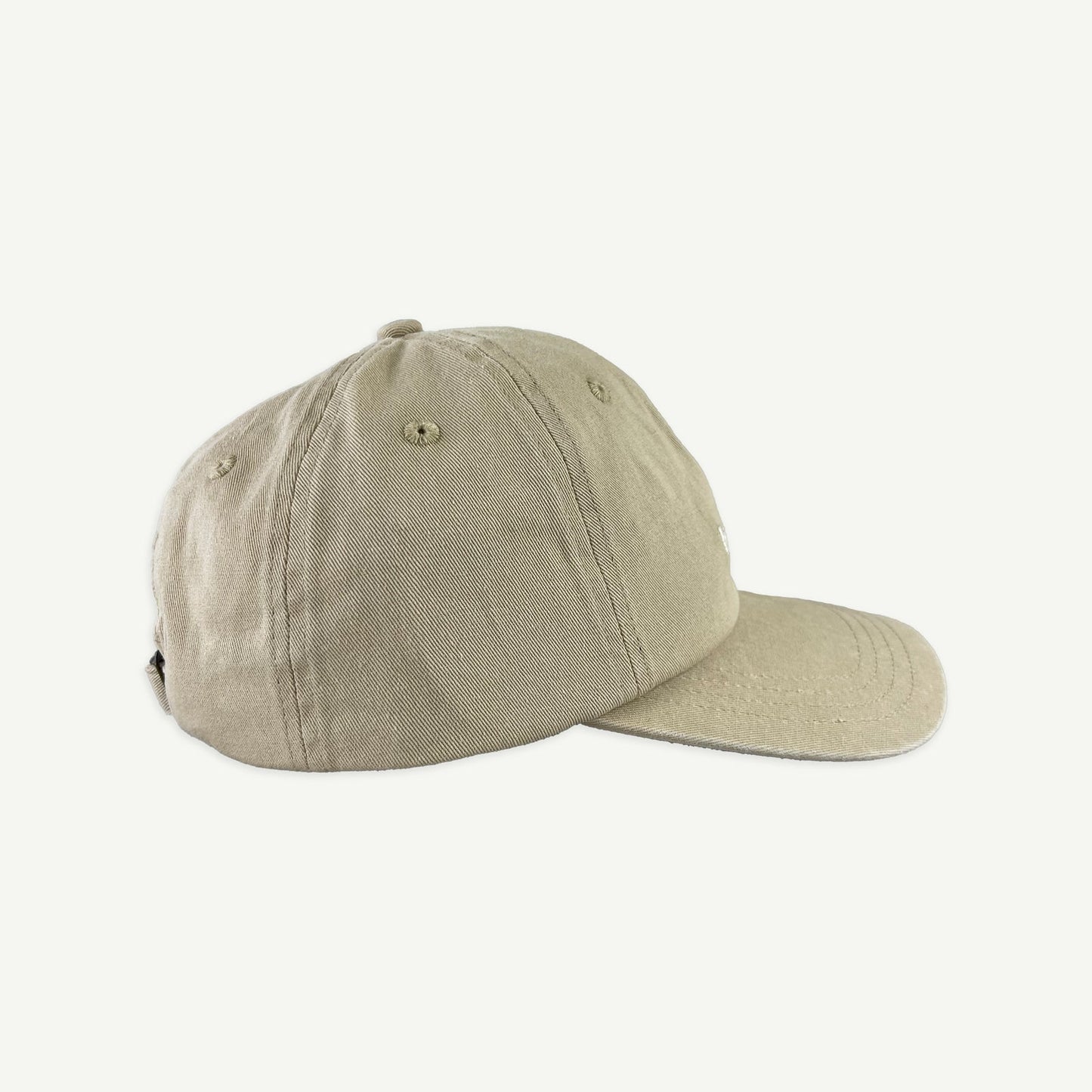 Side view of Banabae washed sand cap in organic cotton twill, Banabae embroidery at the center front in contrast white.  